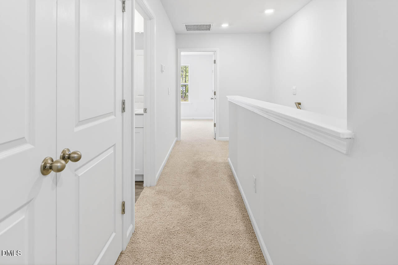 8535 Beckett Chase Way Raleigh, NC 27616 - Photo 33 of 33 a view of a hallway with wooden floor and a bathroom