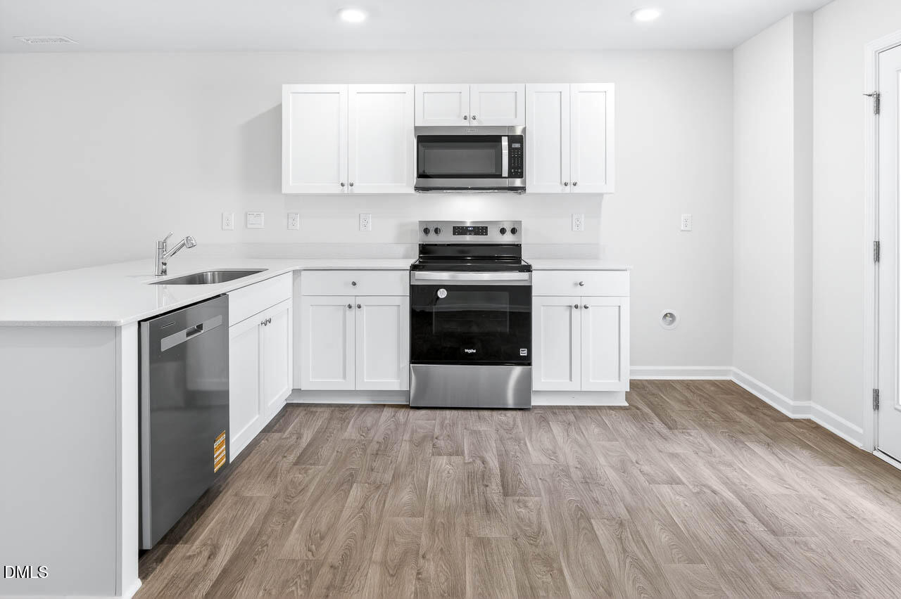 8535 Beckett Chase Way Raleigh, NC 27616 - Photo 7 of 33 a kitchen with wooden floors and a stove top oven