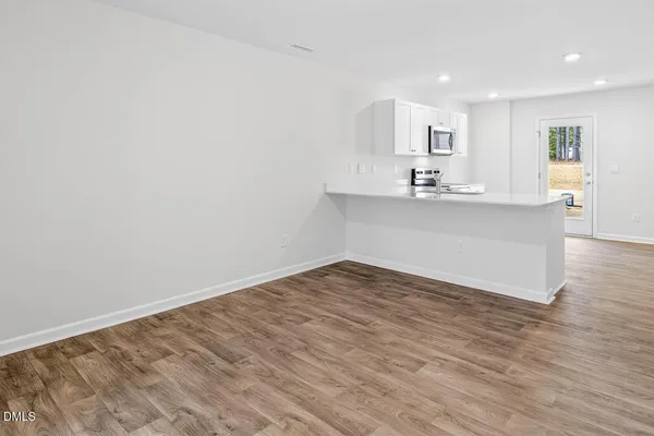 a view of a kitchen with wooden floor and a sink