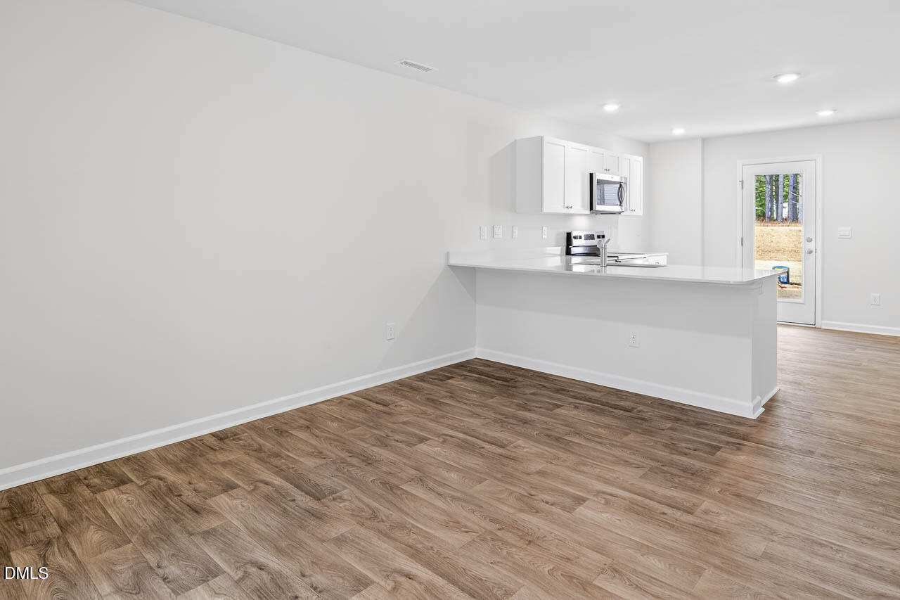 8535 Beckett Chase Way Raleigh, NC 27616 - Photo 9 of 33 a view of a kitchen with wooden floor and a sink