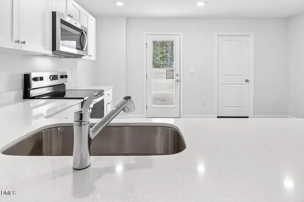 a kitchen with granite countertop a sink and a stove top oven