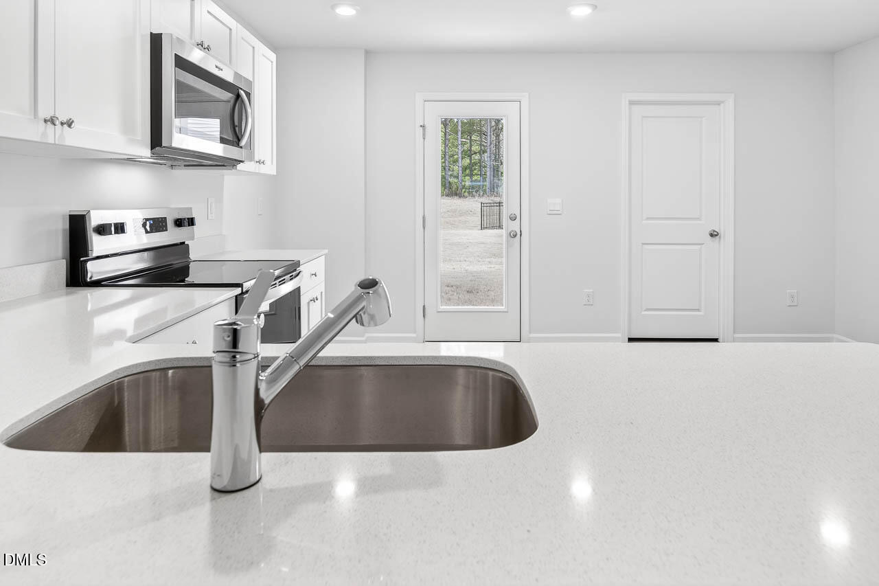 8535 Beckett Chase Way Raleigh, NC 27616 - Photo 10 of 33 a kitchen with granite countertop a sink and a stove top oven