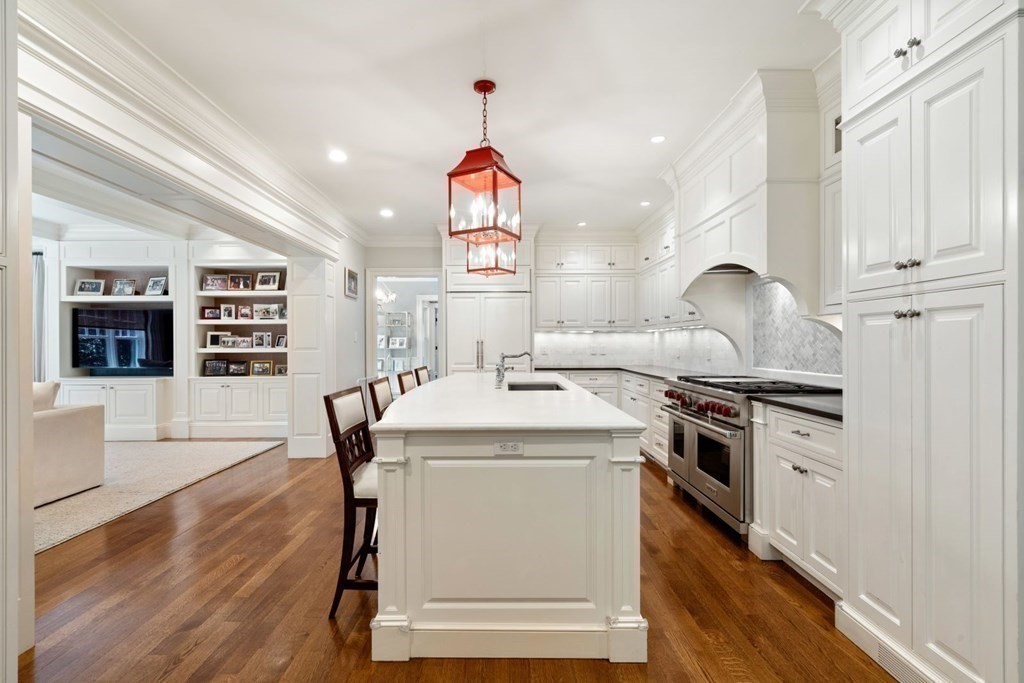 45 Ravine Road Wellesley, MA 02481 - Photo 11 of 42 a kitchen with stainless steel appliances granite countertop a stove top oven a sink dishwasher and a dining table with wooden floor