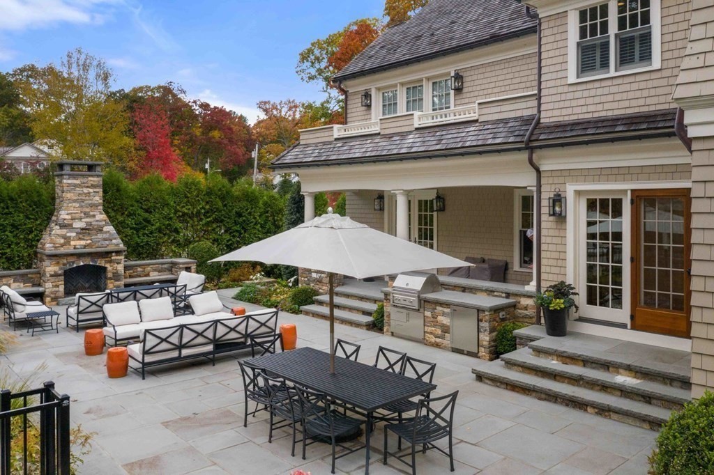45 Ravine Road Wellesley, MA 02481 - Photo 34 of 42 a view of a patio with table and chairs under an umbrella