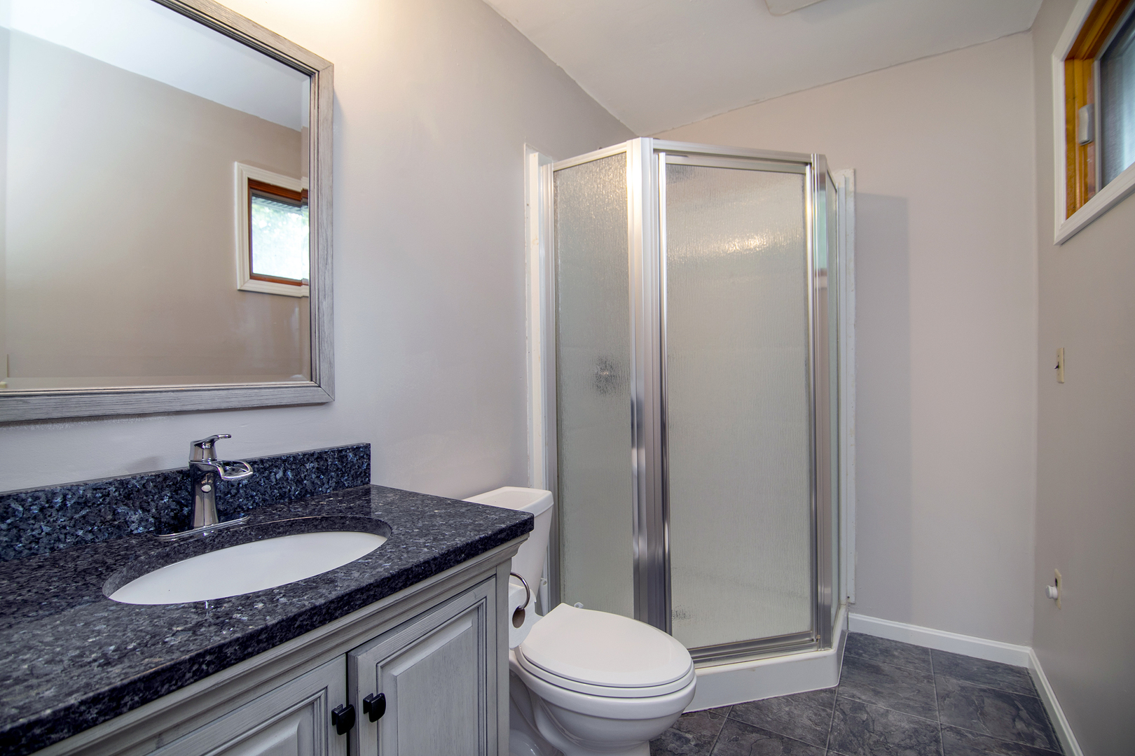 3926 East Chestnut Street Kankakee, IL 60901 - Photo 7 of 14 a bathroom with a granite countertop sink toilet a mirror and shower