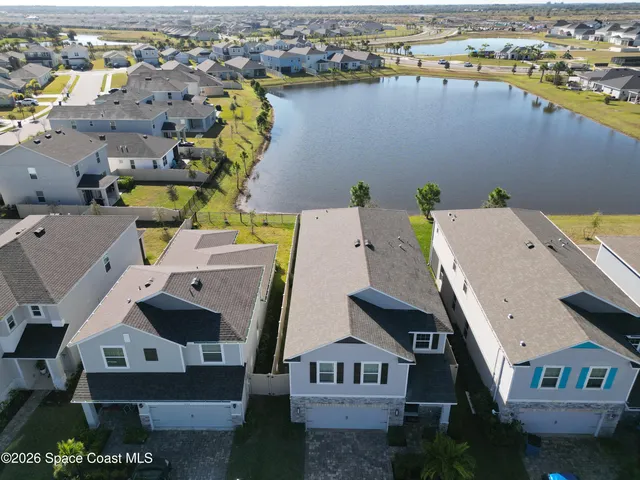 an aerial view of residential houses with outdoor space and ocean view