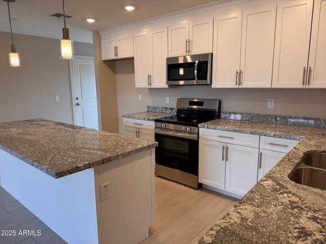 a kitchen with stainless steel appliances granite countertop a sink stove and refrigerator