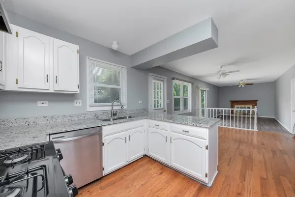 a kitchen with sink cabinets and wooden floor