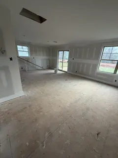 an empty room with windows and cabinet