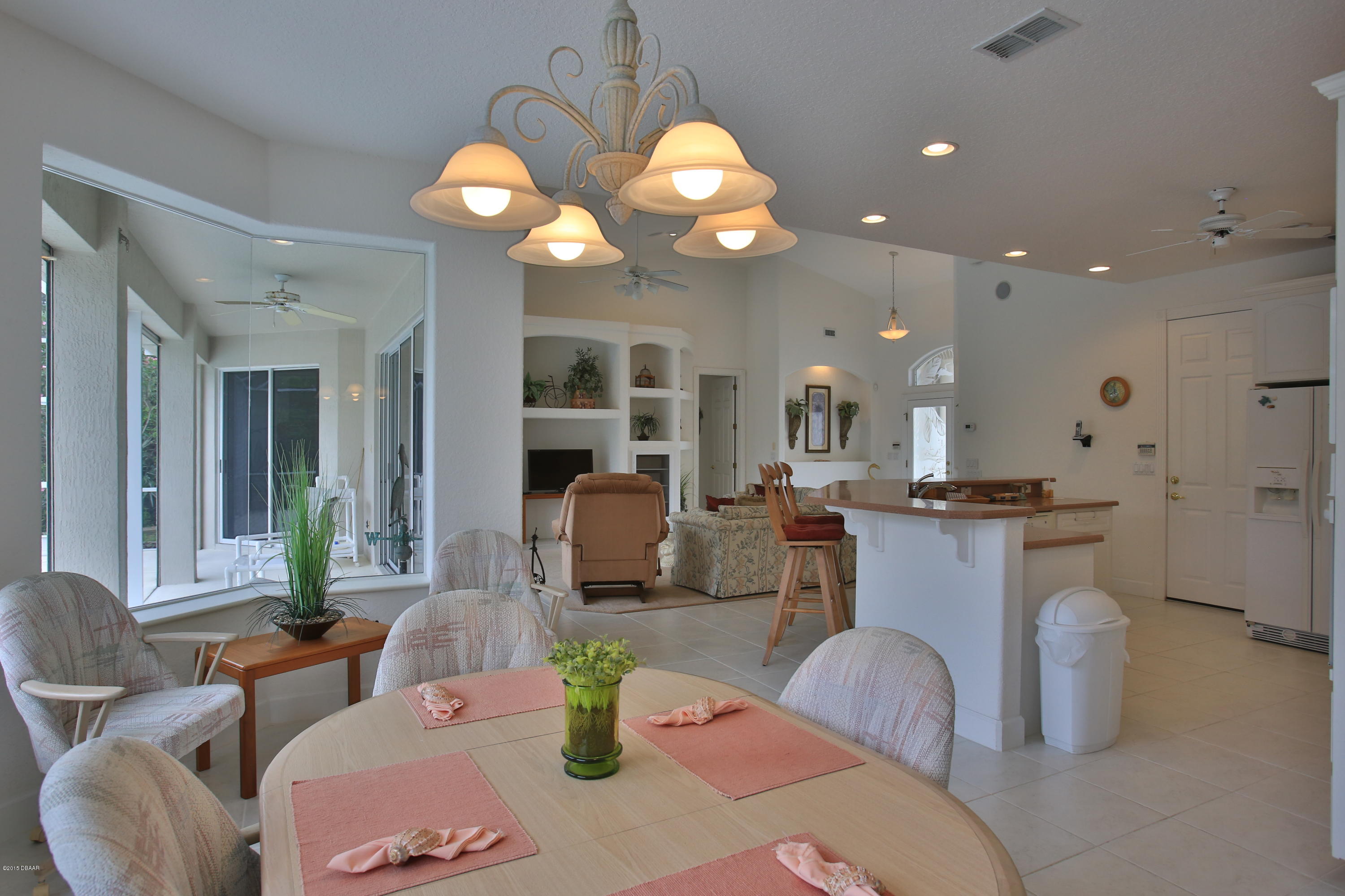 35 Inlet Point Boulevard Ponce Inlet, FL 32127 - Photo 11 of 34 a dining room with wooden floor a chandelier a glass table and chairs