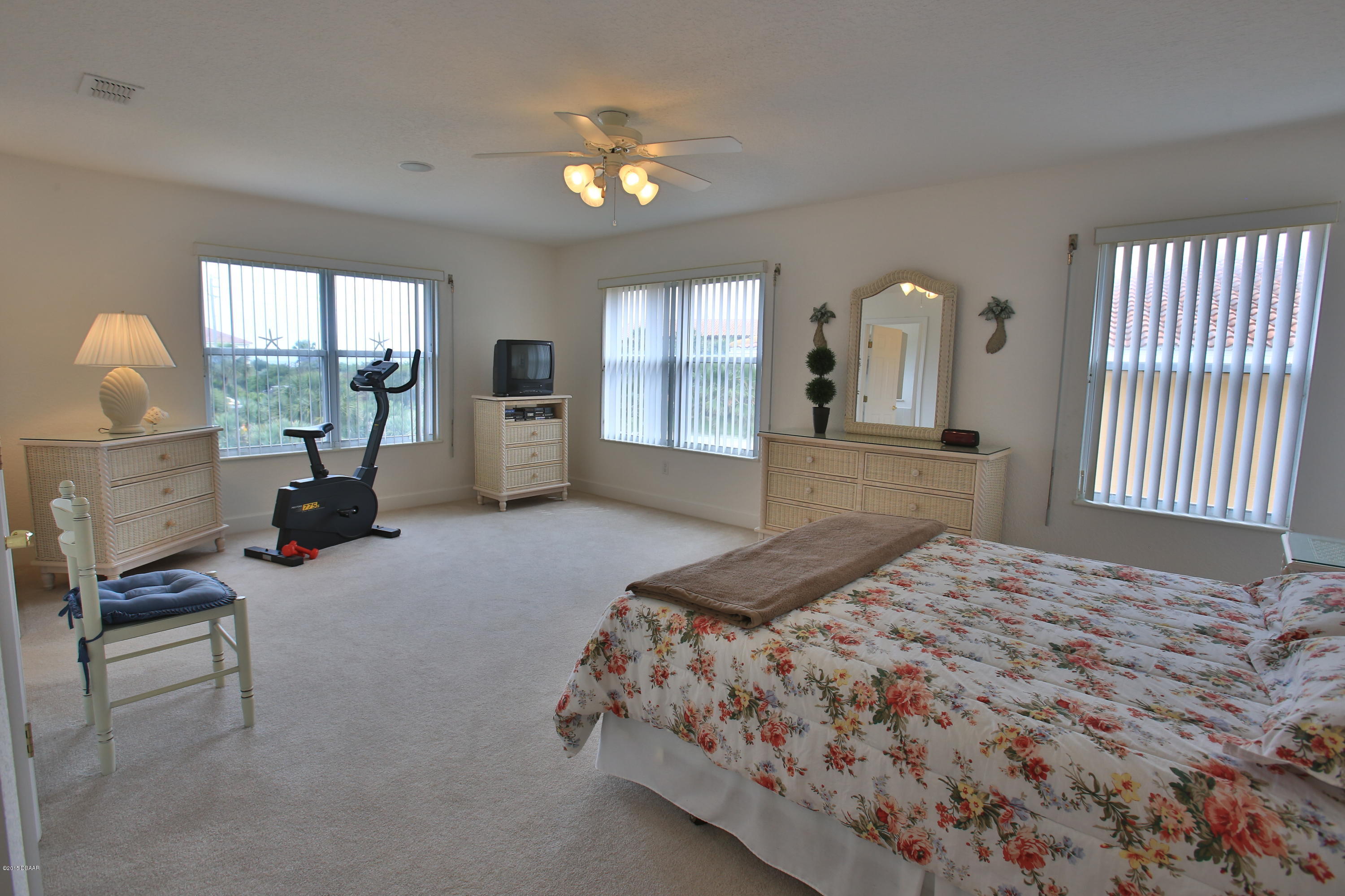 35 Inlet Point Boulevard Ponce Inlet, FL 32127 - Photo 19 of 34 a bedroom with a bed and large windows