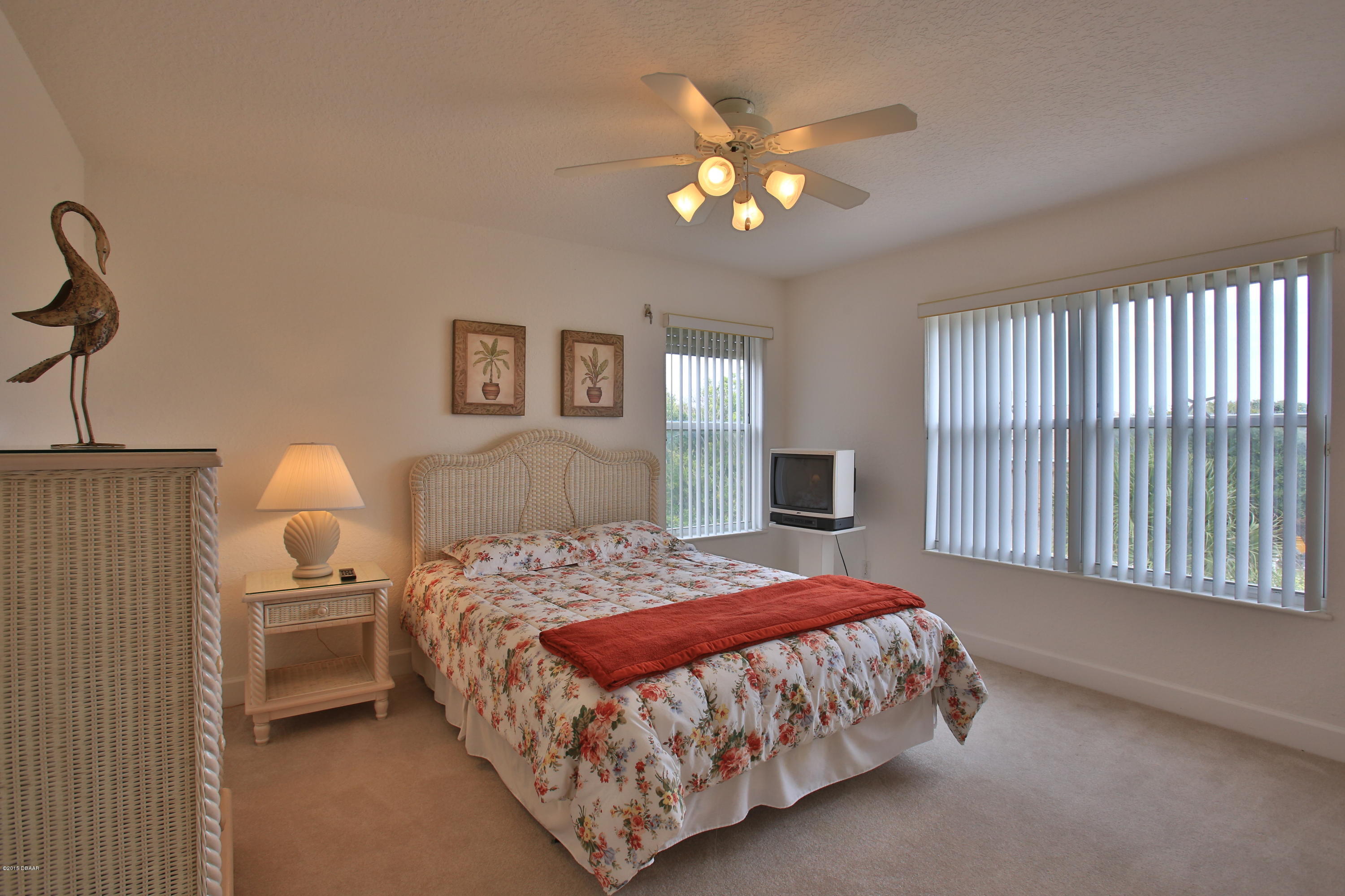 35 Inlet Point Boulevard Ponce Inlet, FL 32127 - Photo 21 of 34 a bedroom with a bed and a chandelier