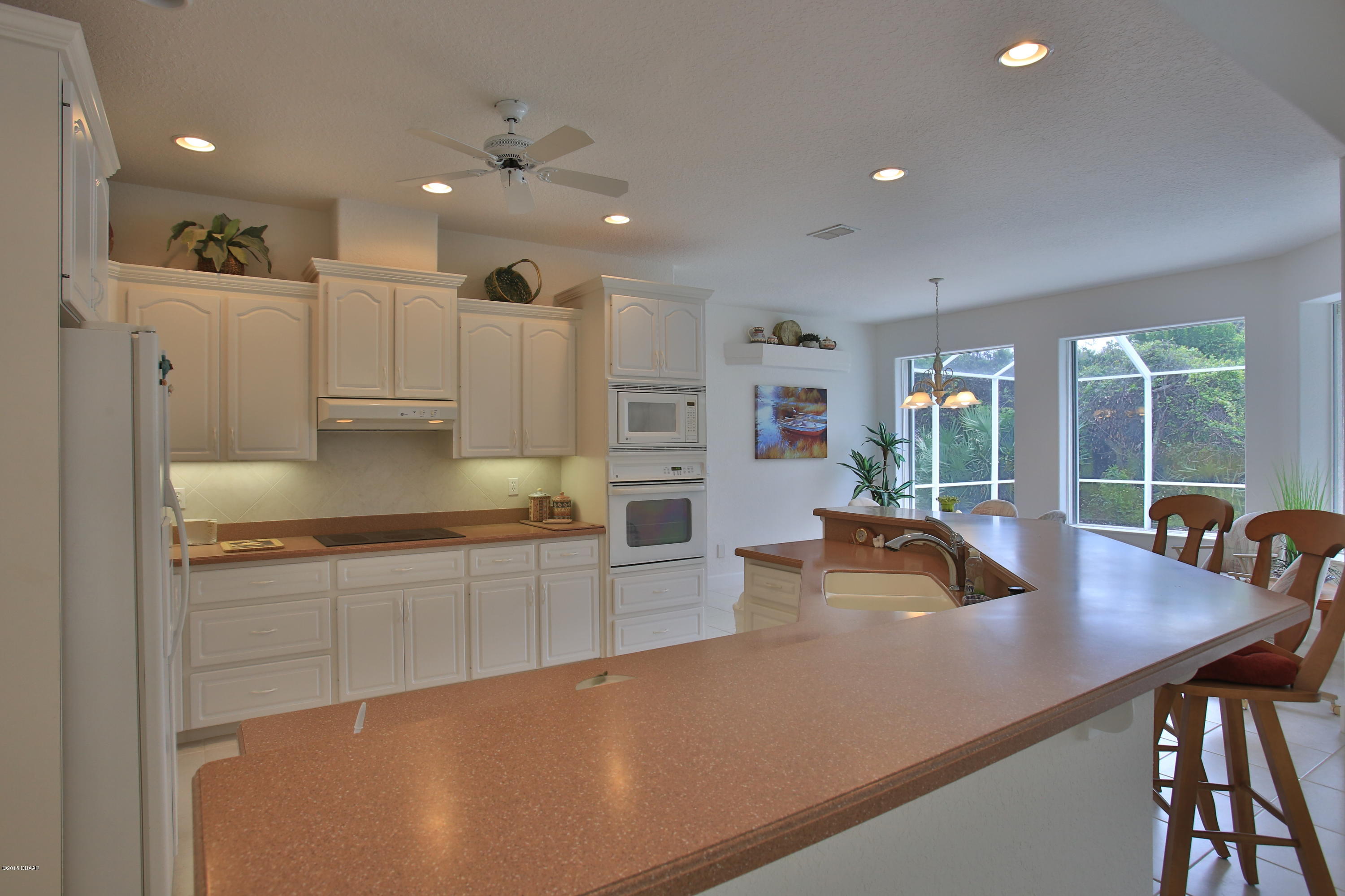 35 Inlet Point Boulevard Ponce Inlet, FL 32127 - Photo 5 of 34 a kitchen with stainless steel appliances granite countertop a sink a stove and white cabinets