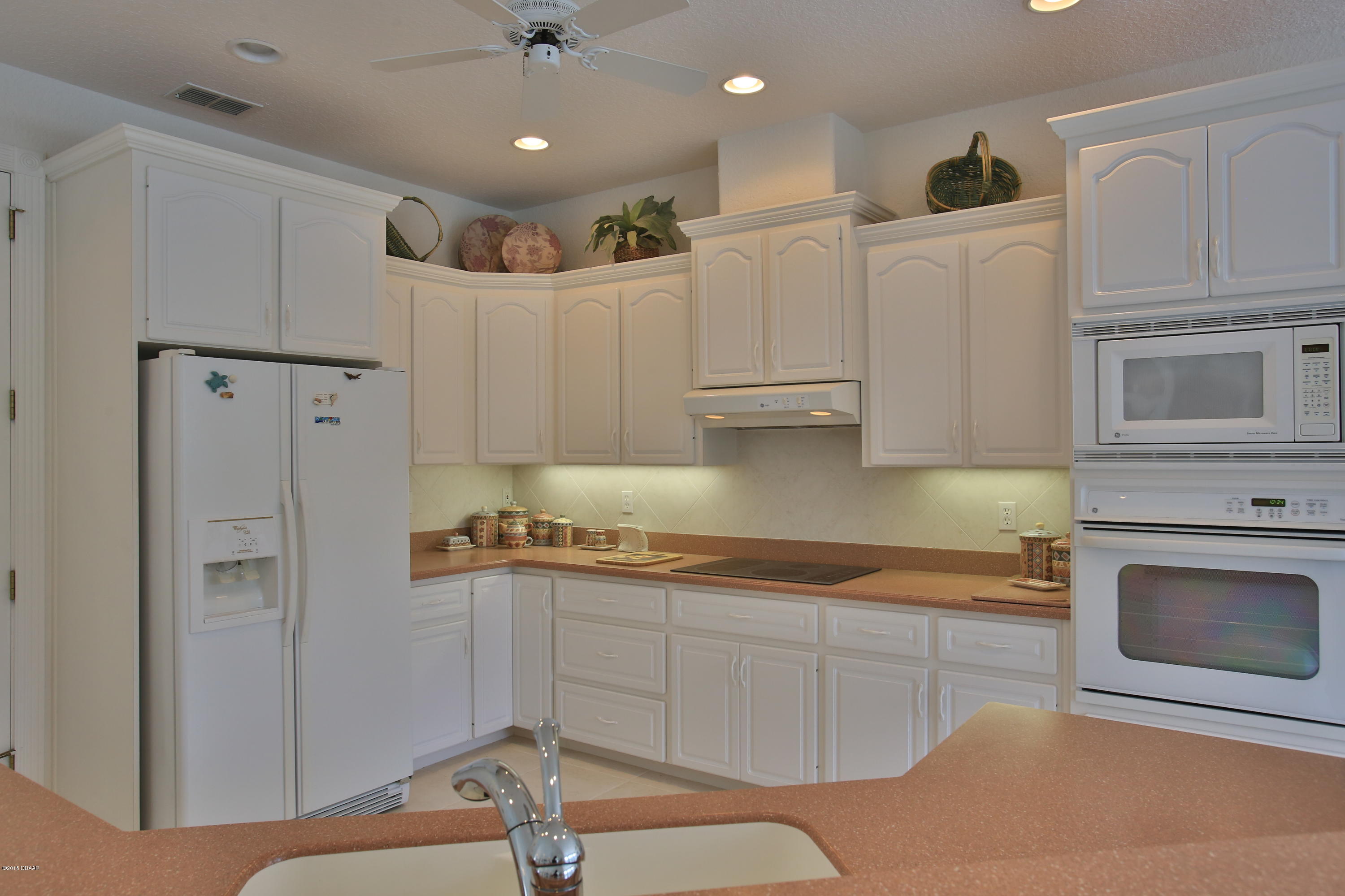 35 Inlet Point Boulevard Ponce Inlet, FL 32127 - Photo 7 of 34 a kitchen with stainless steel appliances granite countertop a refrigerator sink and white cabinets