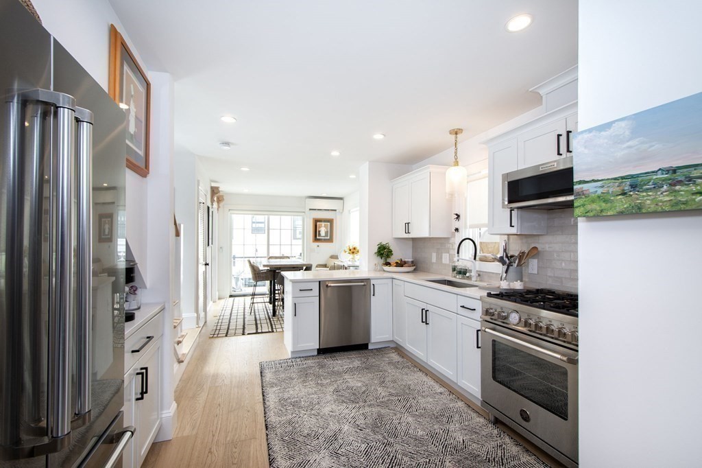 83 Glades Road Scituate, MA 02066 - Photo 8 of 37 a large kitchen with stainless steel appliances granite countertop a stove and a refrigerator