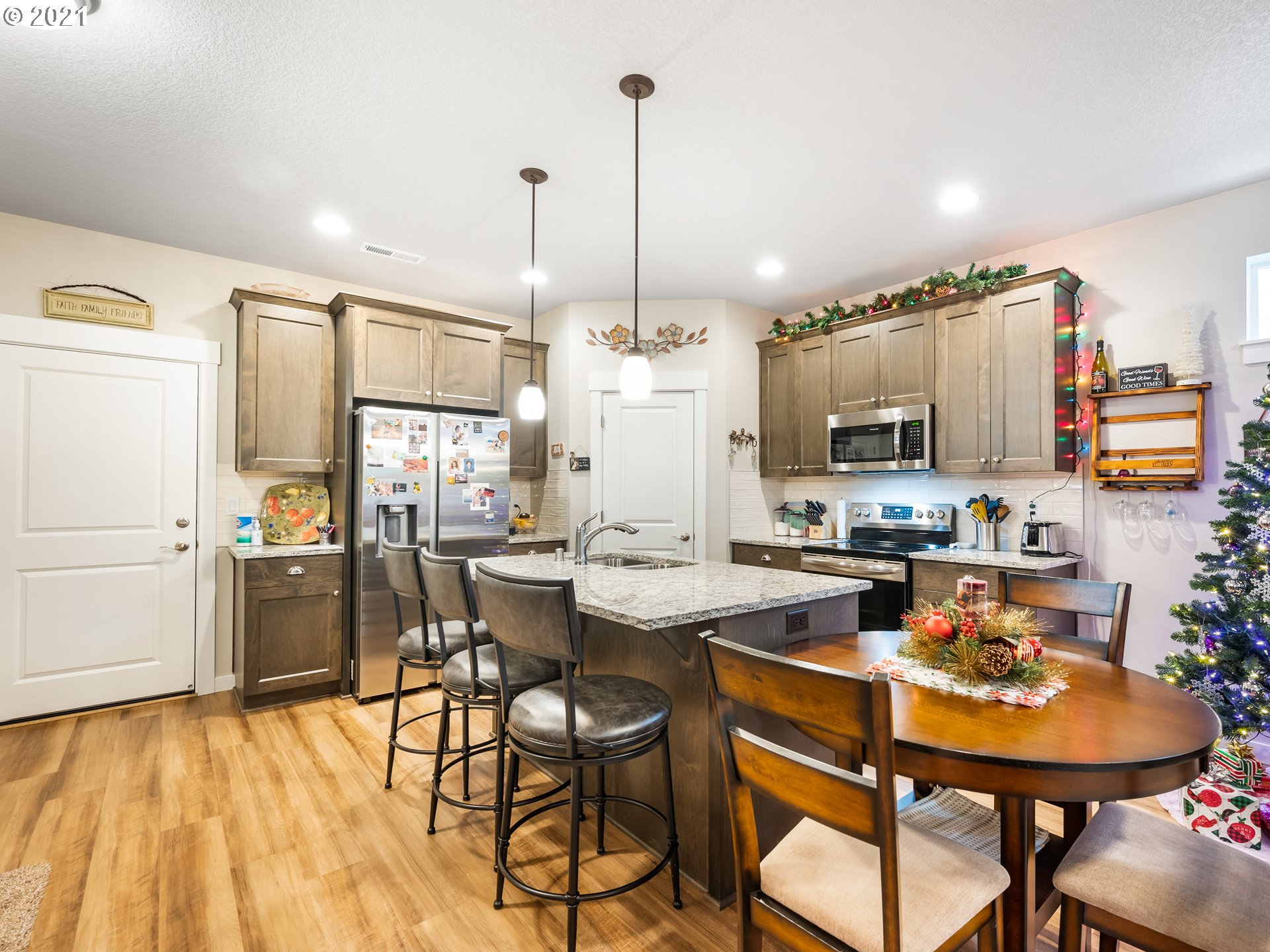 1133 South Union Place Ridgefield, WA 98642 - Photo 6 of 27 a kitchen with stainless steel appliances a dining table chairs and white cabinets