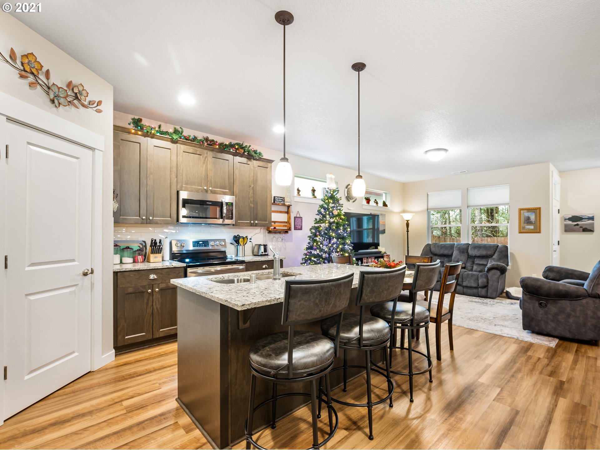 1133 South Union Place Ridgefield, WA 98642 - Photo 8 of 27 a kitchen with stainless steel appliances kitchen island granite countertop a dining table chairs and white cabinets