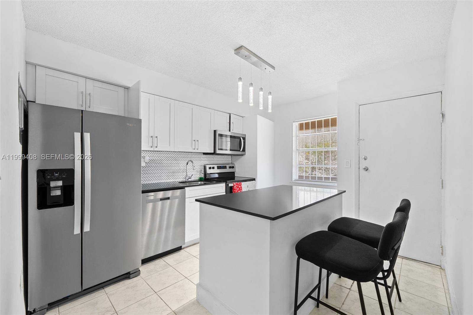 515 Southwest 3rd Street, Unit 6 Miami, FL 33130 - Photo 5 of 19 a kitchen with stainless steel appliances a refrigerator a stove a sink dishwasher and a refrigerator with wooden floor