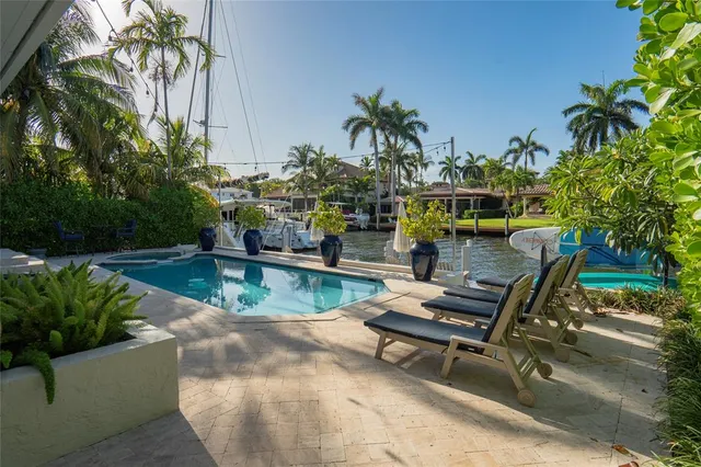a view of house with swimming pool and outdoor seating