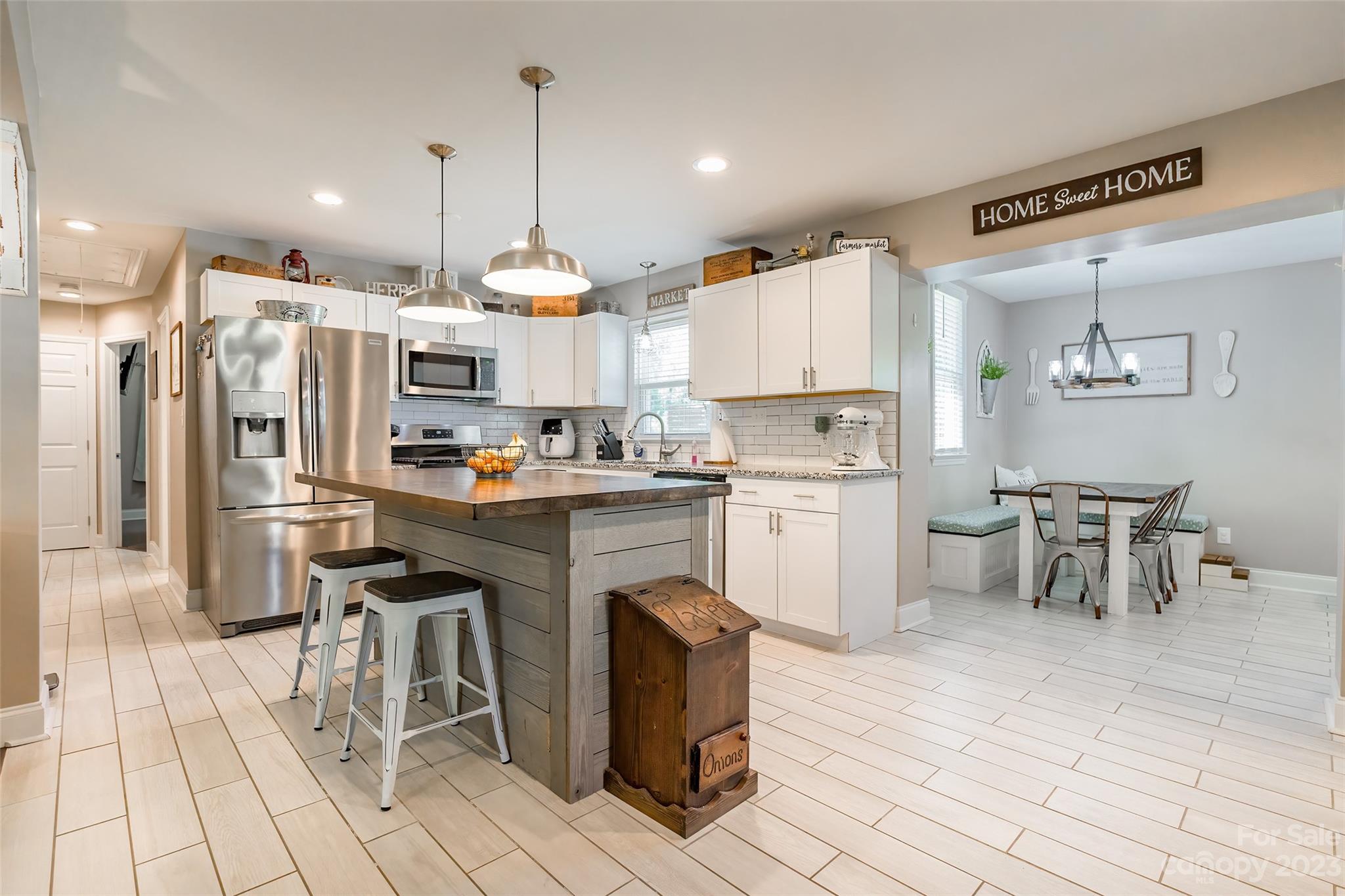1514 Shiloh Unity Road Lancaster, SC 29720 - Photo 6 of 26 a kitchen with granite countertop a table chairs microwave and cabinets
