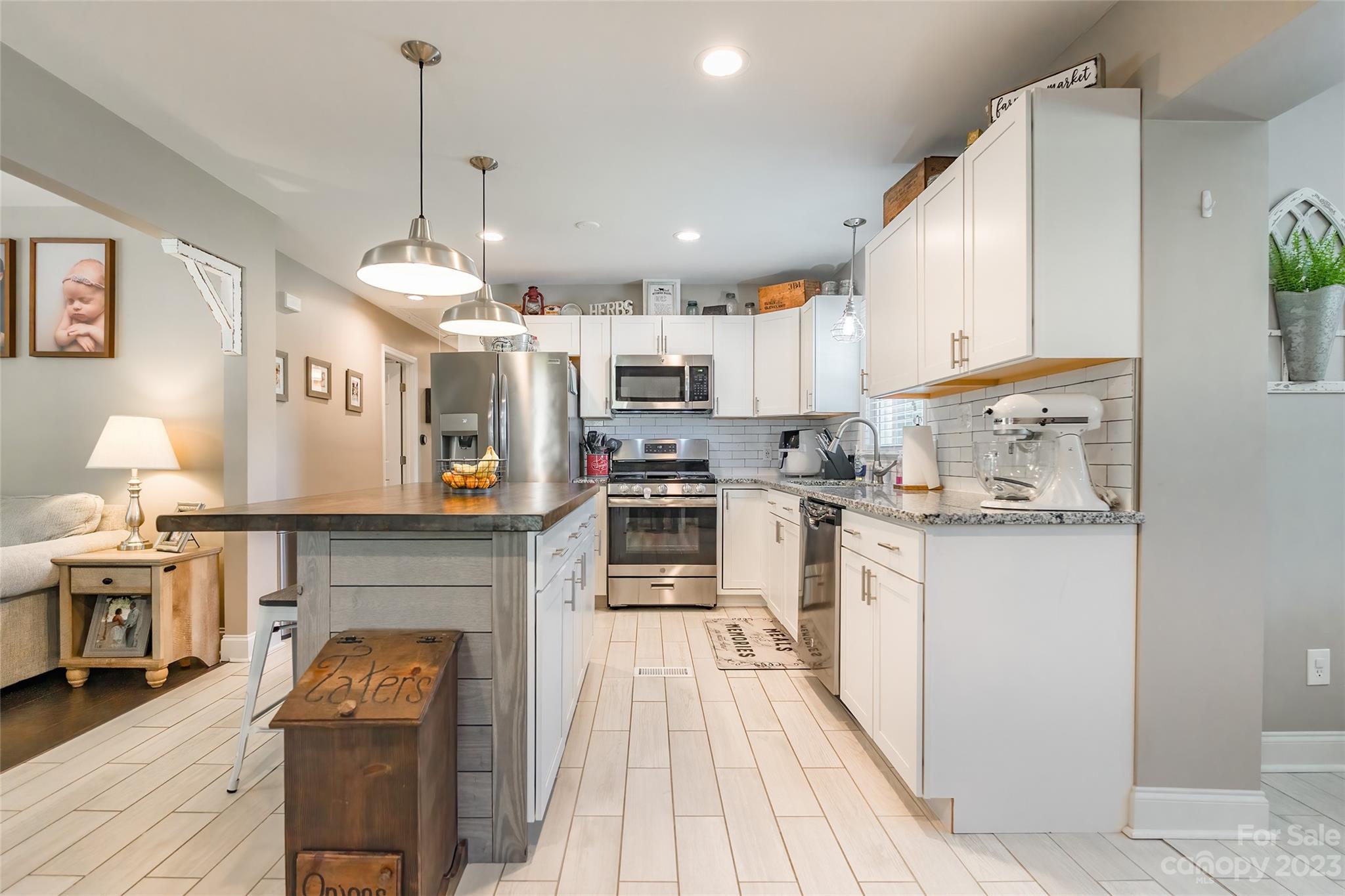 1514 Shiloh Unity Road Lancaster, SC 29720 - Photo 8 of 26 a kitchen with stainless steel appliances kitchen island granite countertop a stove top oven a sink a dining table and chairs with wooden floor