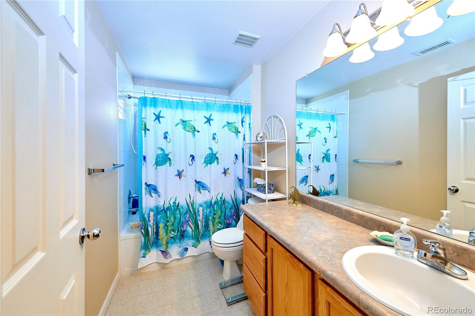 5800 Tower Road, Unit 610 Denver, CO 80249 - Photo 11 of 25 a bathroom with a granite countertop sink a toilet and a mirror