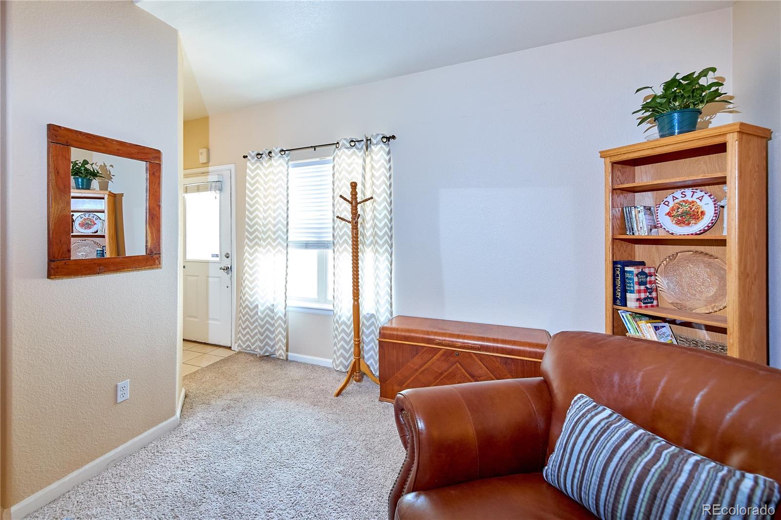 5800 Tower Road, Unit 610 Denver, CO 80249 - Photo 5 of 25 a blue bed sitting in a livingroom next to a window