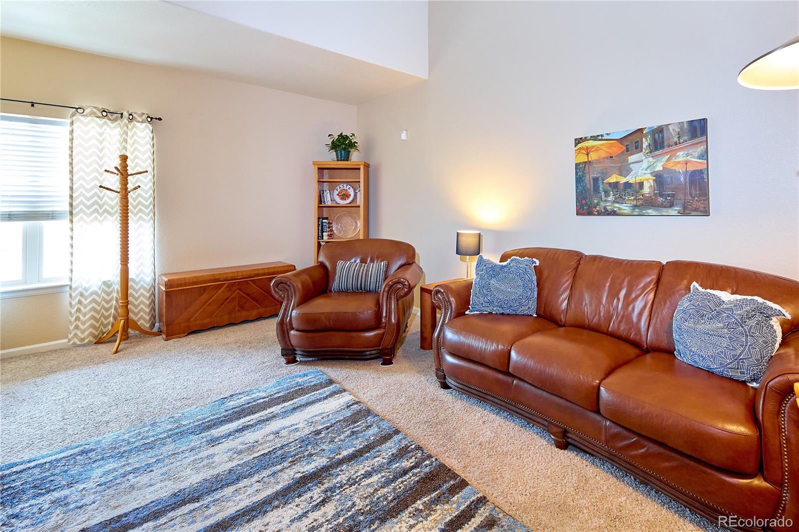 5800 Tower Road, Unit 610 Denver, CO 80249 - Photo 7 of 25 a blue living room with furniture and a rug