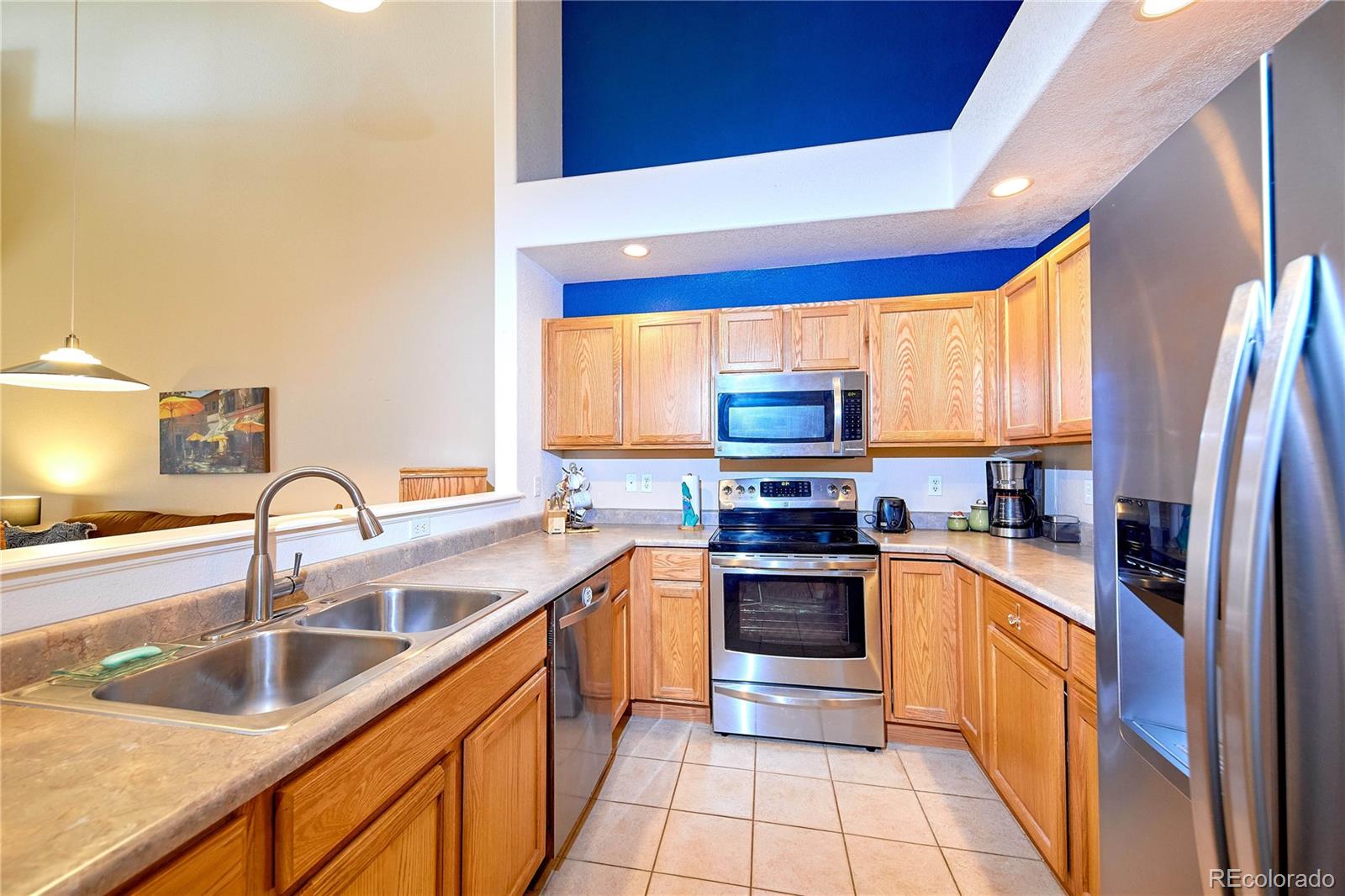 5800 Tower Road, Unit 610 Denver, CO 80249 - Photo 8 of 25 a kitchen with stainless steel appliances granite countertop a sink a stove and refrigerator