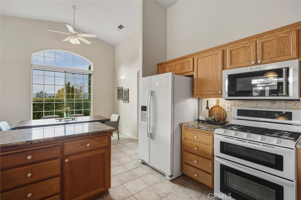 1608 Via Flora Paso Robles, CA 93446 - Photo 20 of 57 a kitchen with granite countertop a refrigerator stove and microwave