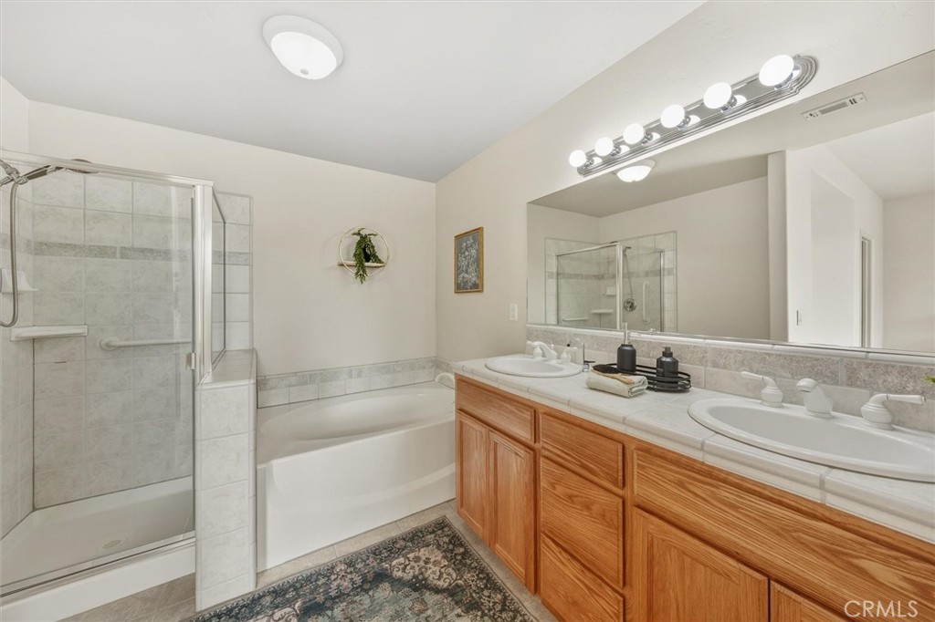 1608 Via Flora Paso Robles, CA 93446 - Photo 25 of 57 a bathroom with a granite countertop sink a mirror and a shower