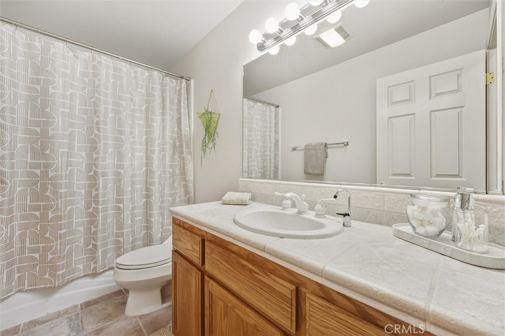 1608 Via Flora Paso Robles, CA 93446 - Photo 33 of 57 a bathroom with a granite countertop sink a toilet and a shower