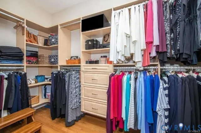 a view of walk in closet with clothes and shoes