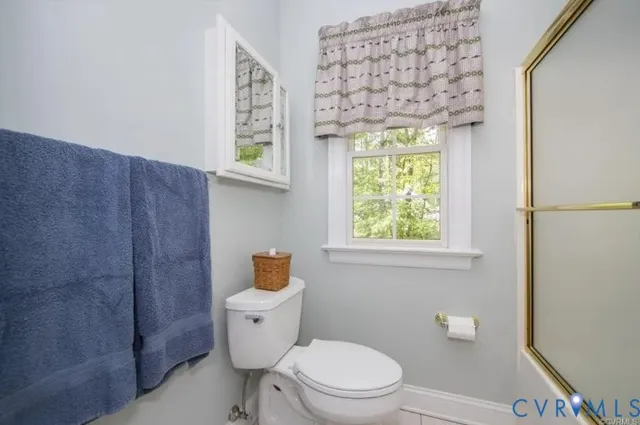 a bathroom with a toilet a sink and a window