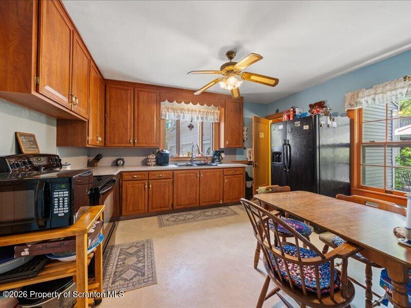 71 Pleasant Avenue Thompson, PA 18465 - Photo 10 of 37 a kitchen with stainless steel appliances kitchen island granite countertop a table chairs in it and wooden floors