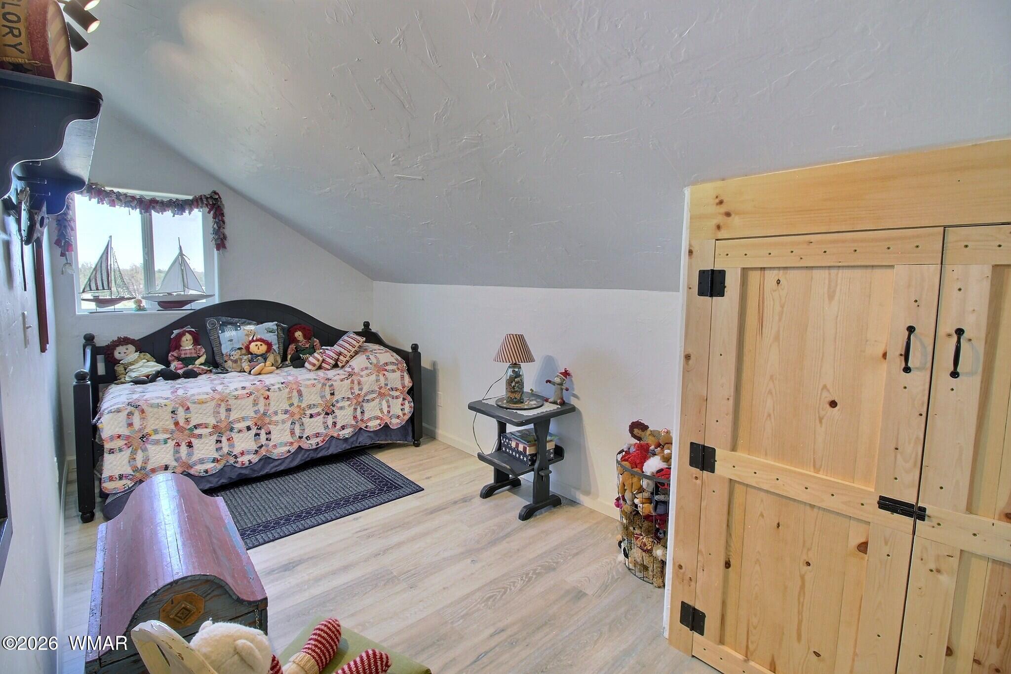 5325 Pinedale Wash Road Pinedale, AZ 85934 - Photo 23 of 32 a bedroom with bed and wooden floor
