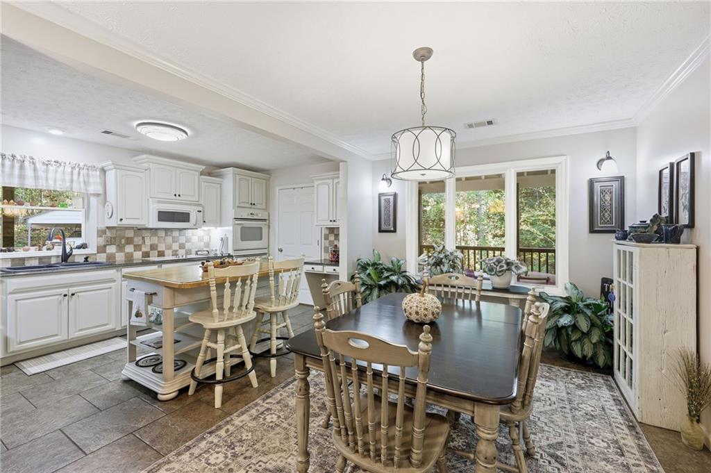 136 Ross Road Mineral Bluff, GA 30559 - Photo 12 of 65 a dining room with furniture a chandelier and kitchen view