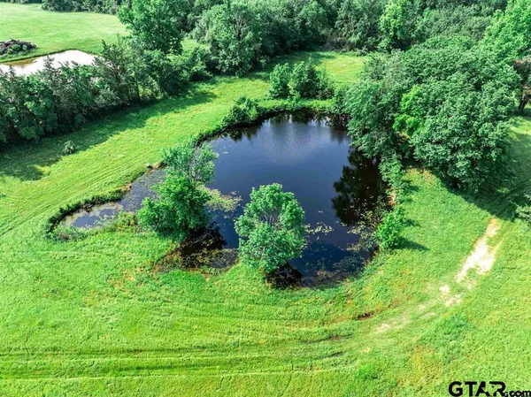 an aerial view of a house with outdoor space patio and trees all around