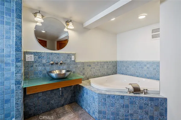 a bathroom with a tub a sink and a window