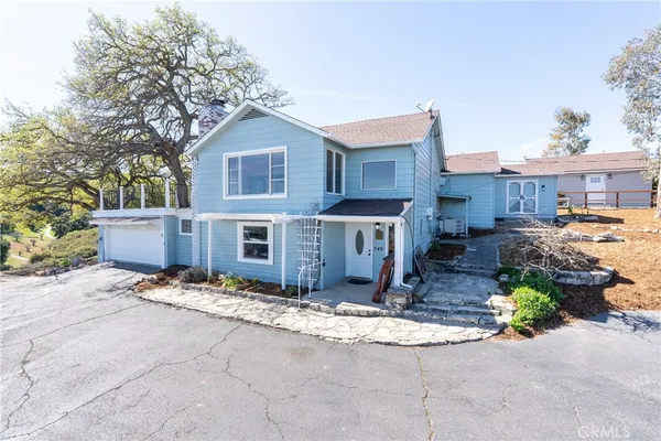 a view of a house with a yard and large tree