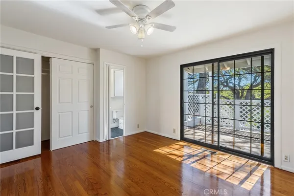a bedroom with a balcony and wooden floor