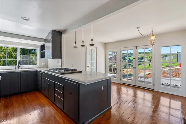 a kitchen with stainless steel appliances granite countertop a stove and a large window