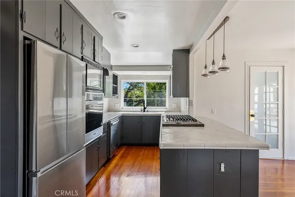 a kitchen with stainless steel appliances granite countertop a refrigerator a stove and a sink