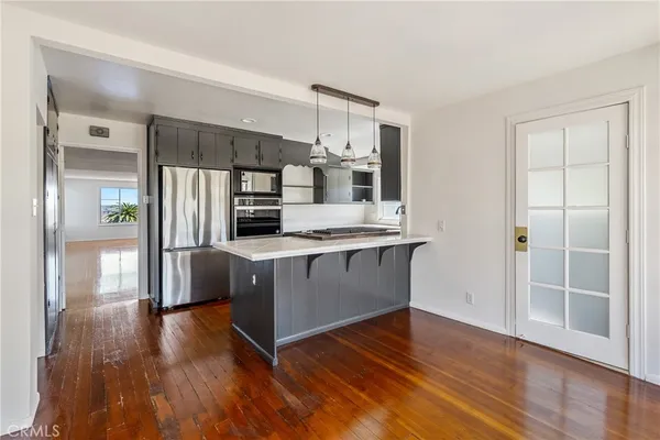 a kitchen with stainless steel appliances granite countertop a refrigerator and a stove top oven