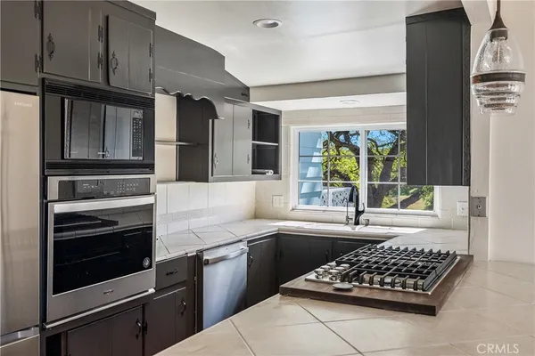a kitchen with stainless steel appliances kitchen island granite countertop a stove and a refrigerator