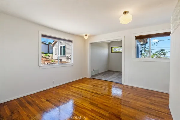 a view of empty room with wooden floor