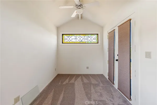 an empty room with a ceiling fan and a window