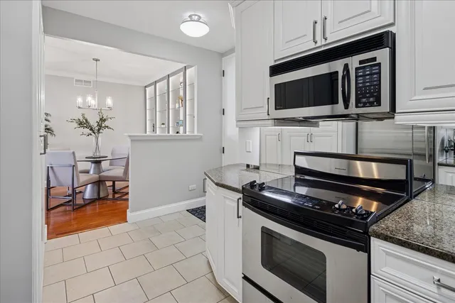 a kitchen with granite countertop a stove top oven and cabinets