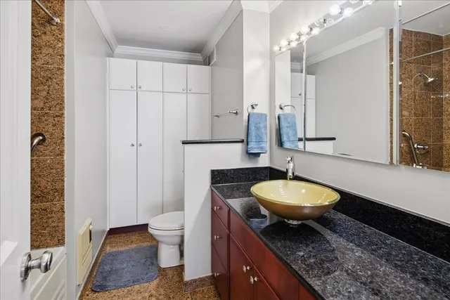 a bathroom with a granite countertop toilet a mirror and a sink