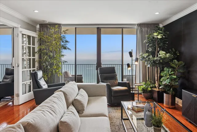 a living room with furniture plant and a large window